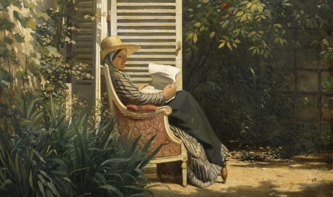 Femme lisant devant une maison dans un jardin